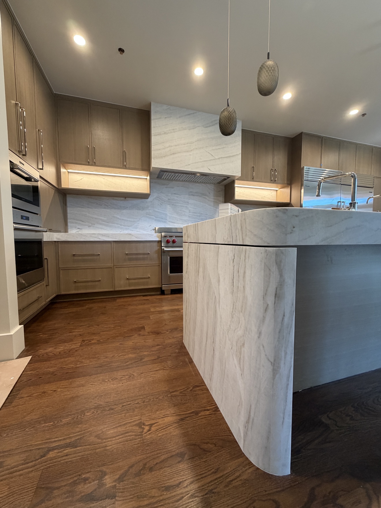 Parker kitchen with stained white oak frameless cabinetry and dark upper cabinets