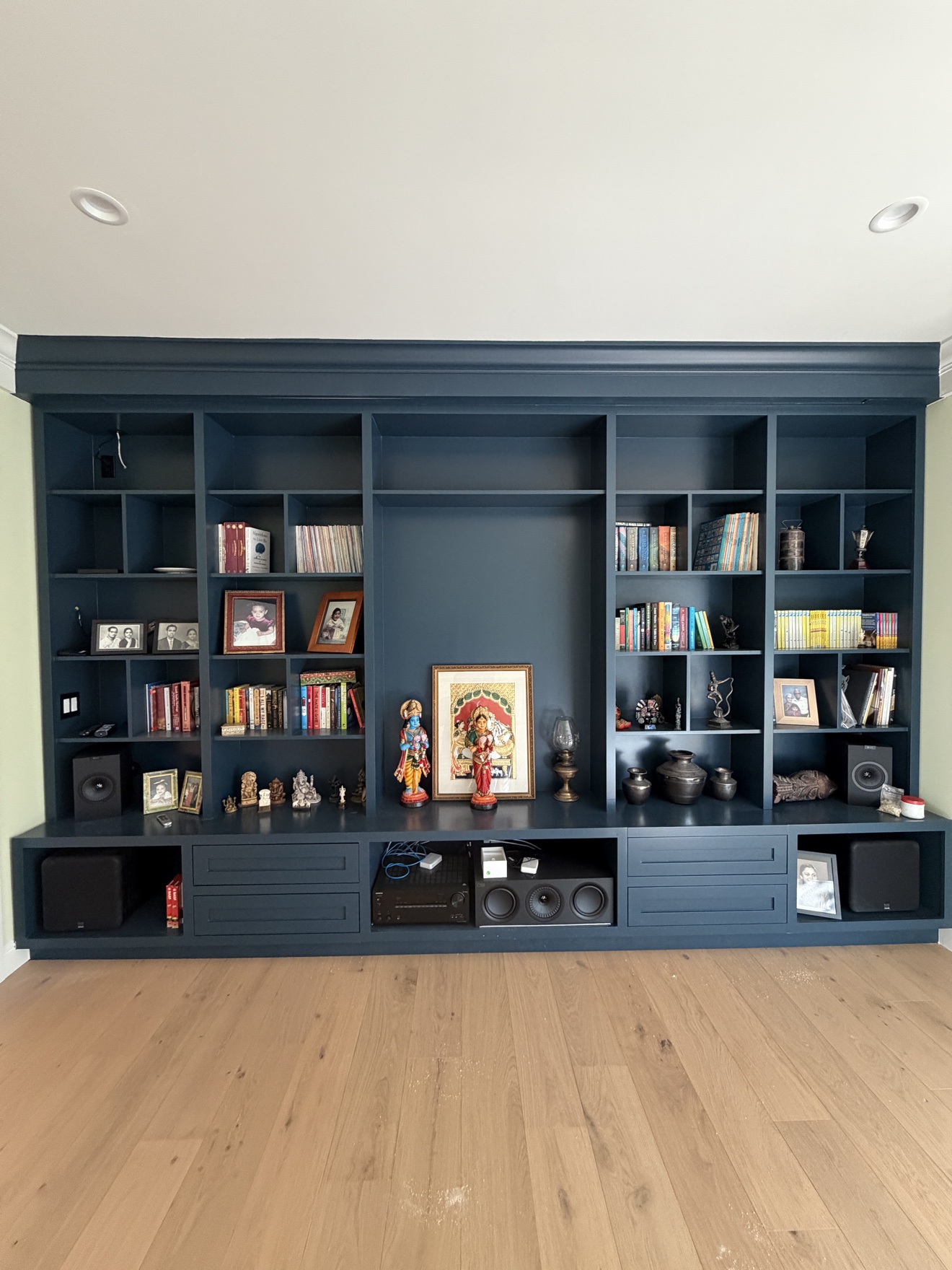 Lopez Ave full-wall built-in library and media cabinet in deep navy with drawers and styled bookshelves