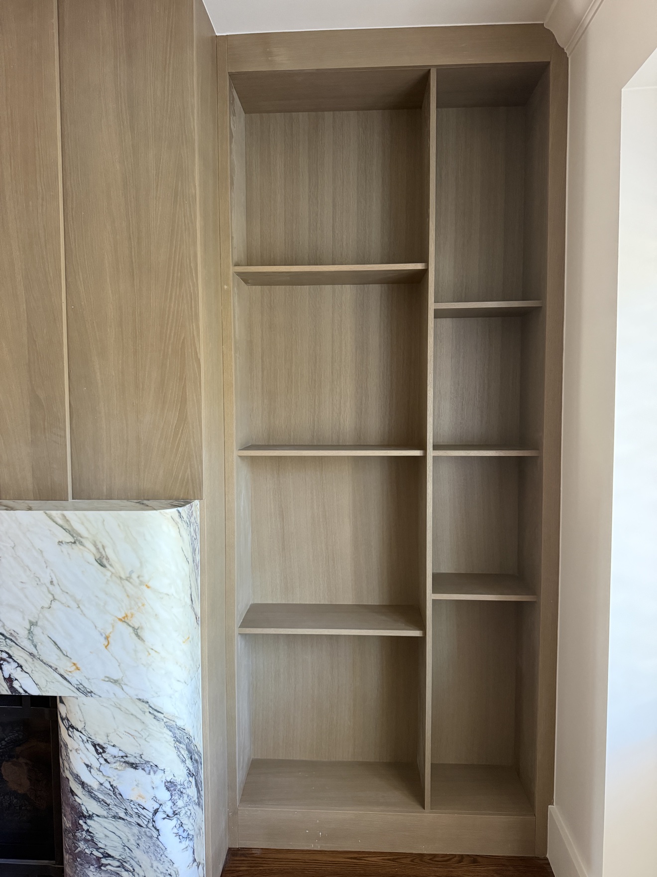 Stained white oak open shelving beside the Parker fireplace