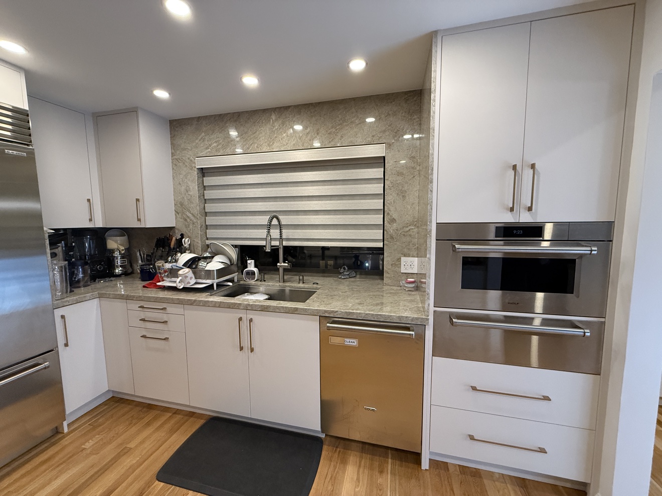 Kenwood St white flat-panel kitchen: sink run beside a built-in wall oven stack