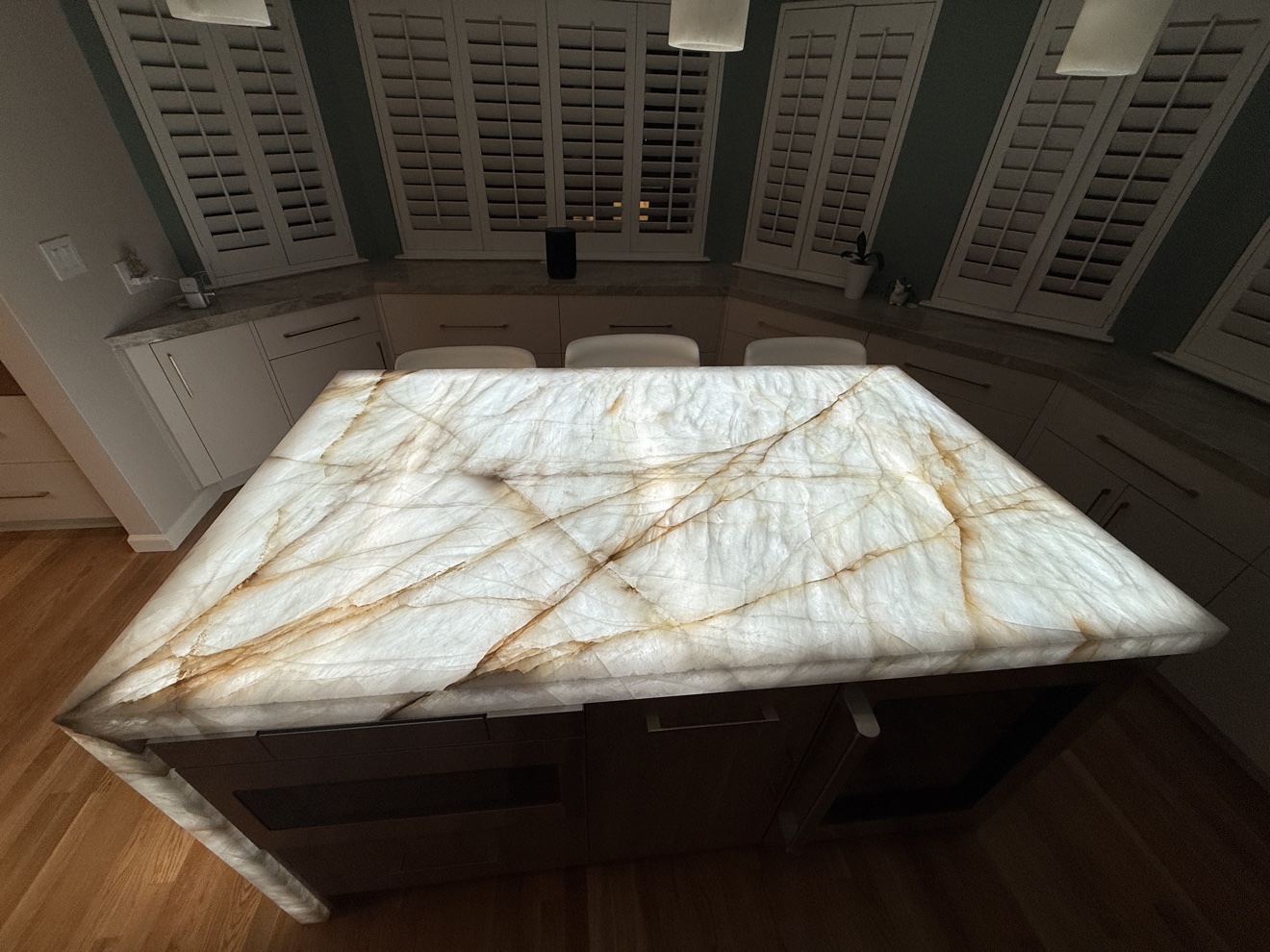Kenwood St glowing backlit onyx waterfall island beside the bay-window seating