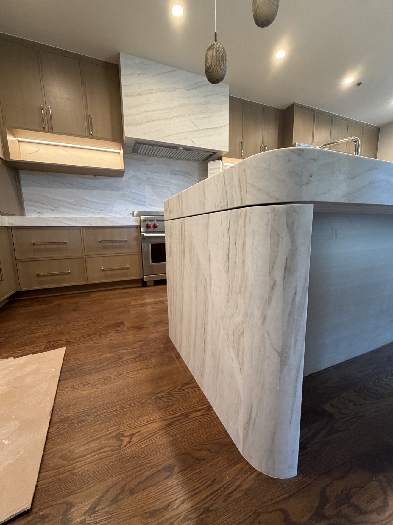 Parker kitchen island with stained white oak cabinetry and waterfall countertop