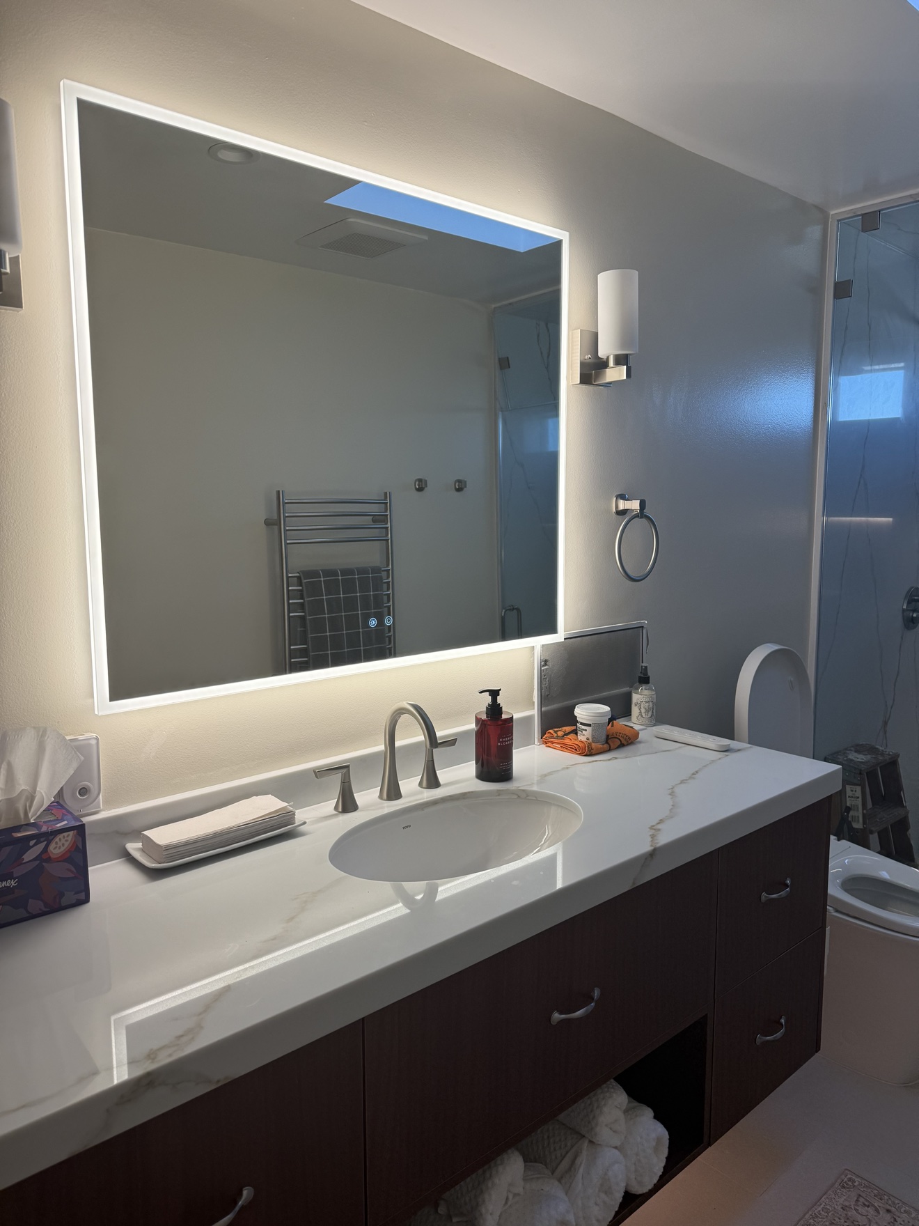 SSF backlit LED mirror above the walnut vanity and white quartz countertop