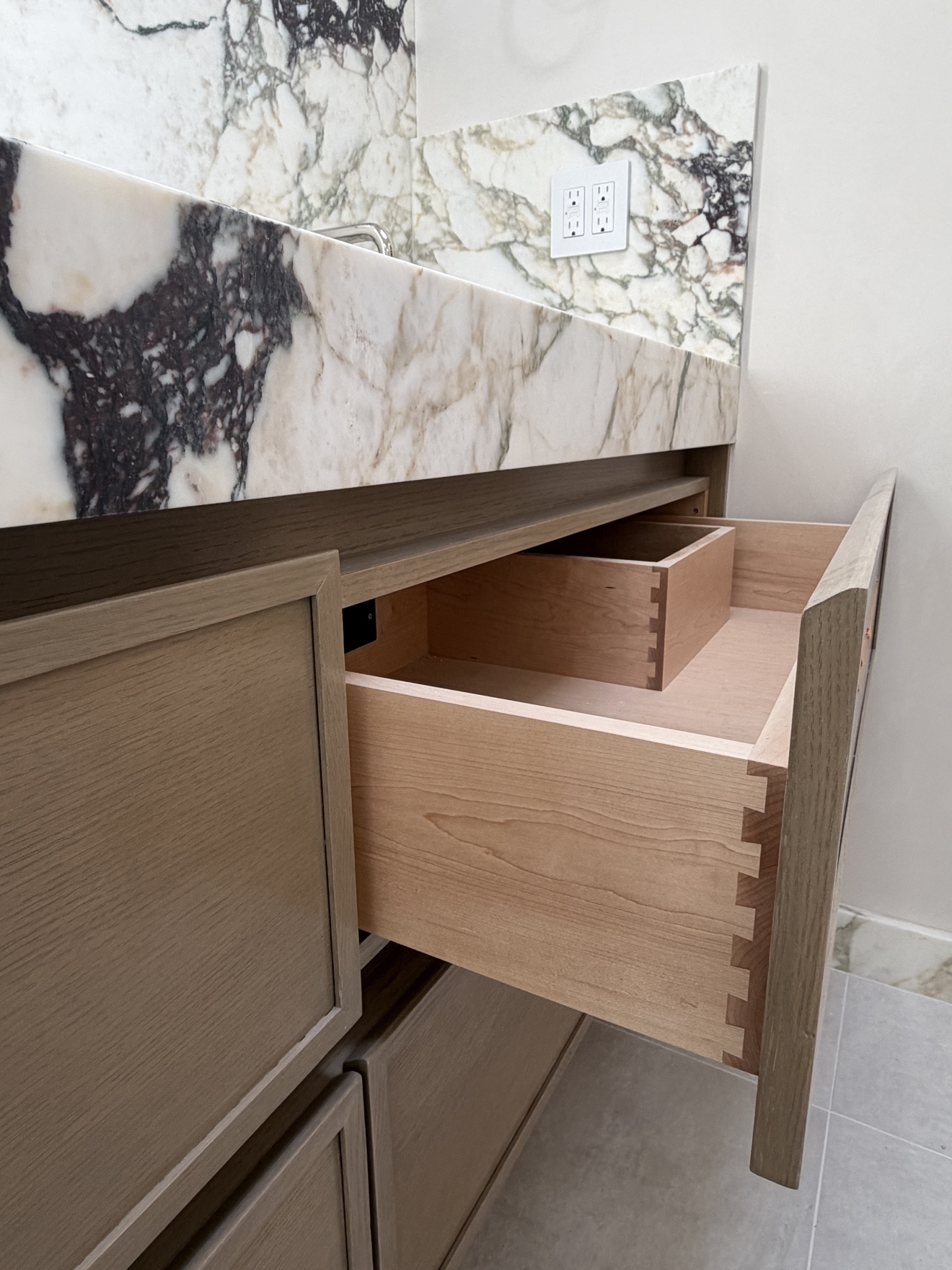 Open frameless drawer in the Parker stained white oak bathroom vanity